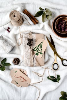 Beautifully arranged Christmas gift wrapping with tags, cinnamon, and greenery.